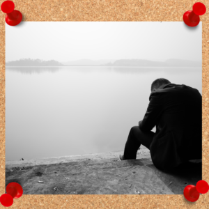 Business man sits in front of a body of water as he slouches in defeat. Learning from failure requires thought and reflection, much like a calm lake.