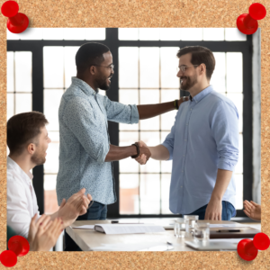 Two businessmen shake hands in an office setting.