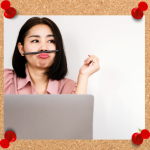 A female employee sits in front of her computer with a pencil balanced on her upper lip.